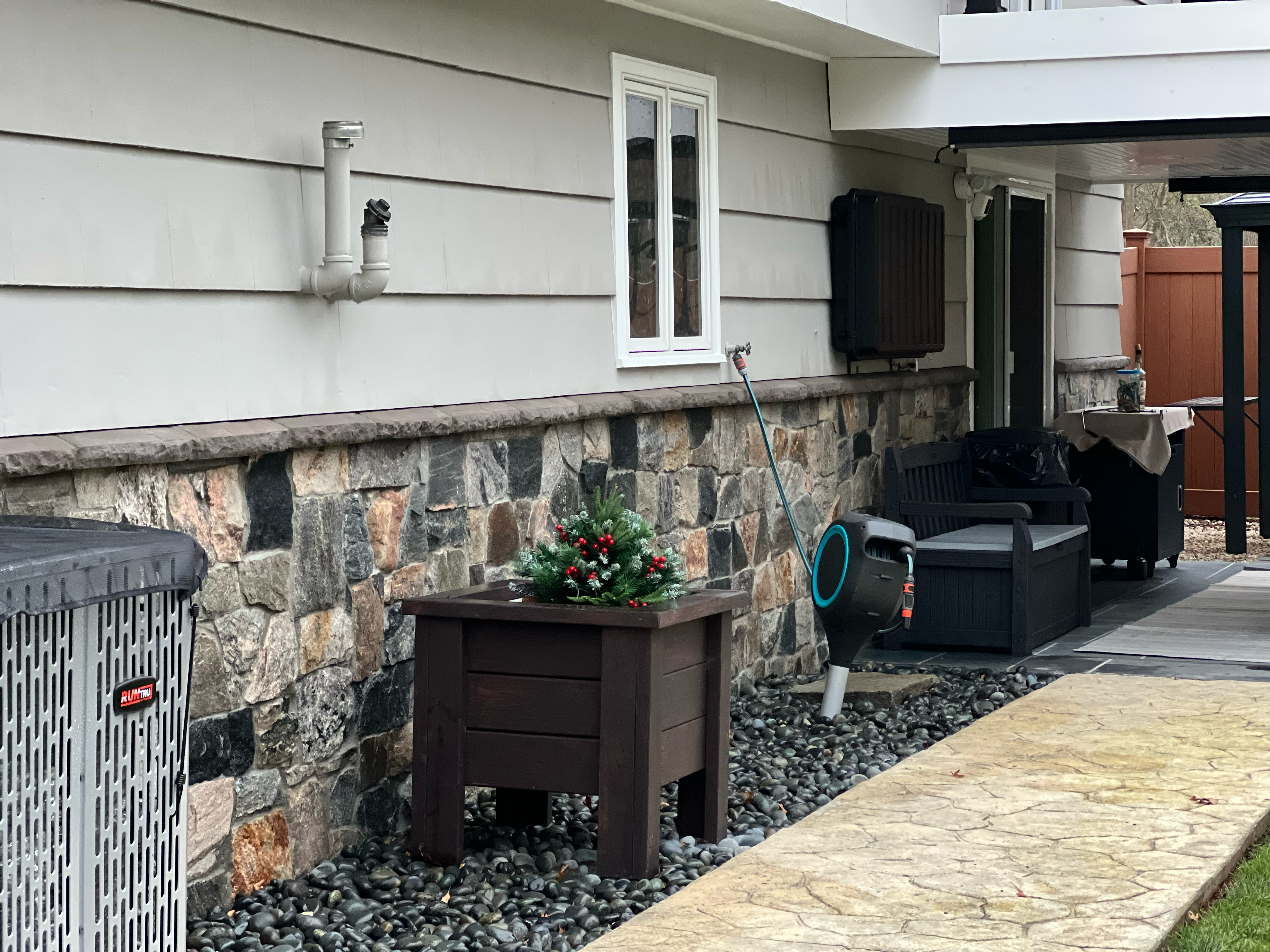 Stone-faced front steps with bluestone treads and a paver landing, flanked by copper planters